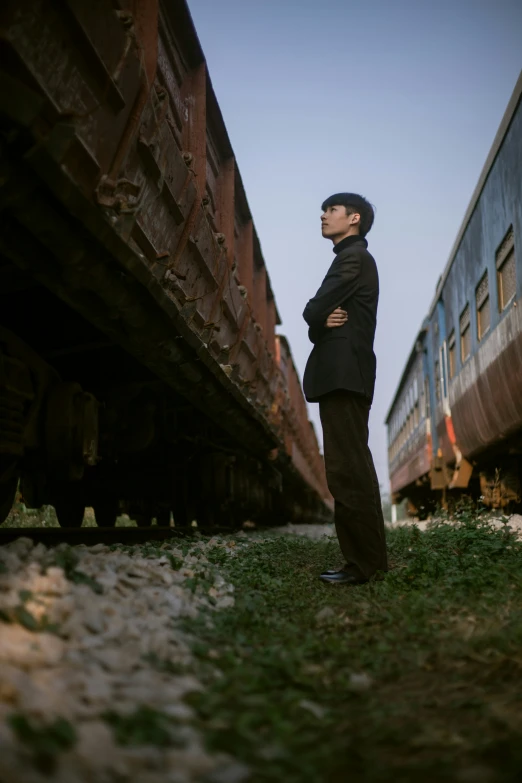 a man standing next to a train on tracks