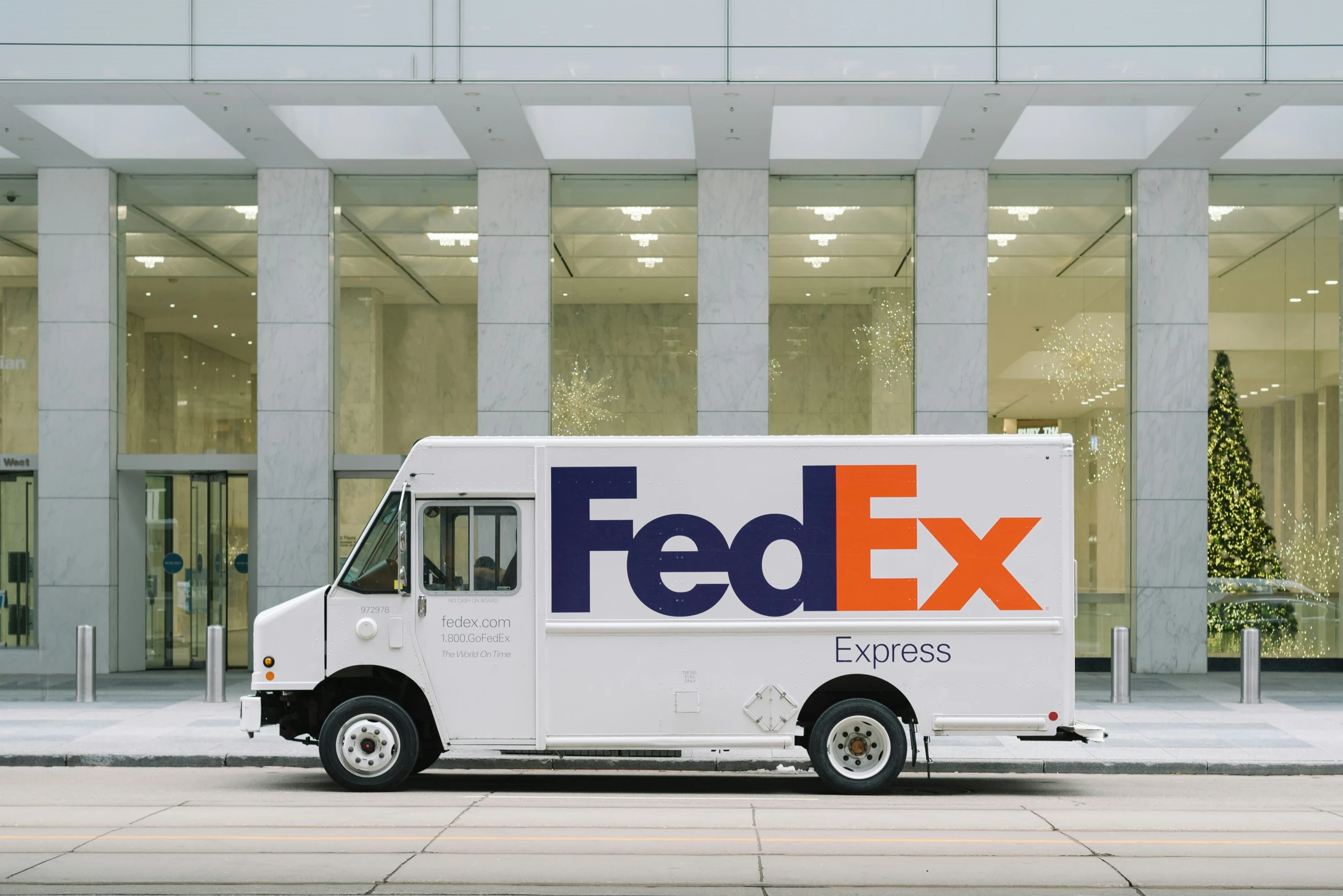 the fedex truck is parked outside of the building