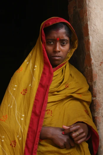 a woman wearing yellow cloths and a red cloth on her head