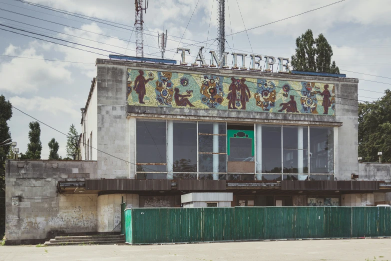 a dilapidated building with a balcony and sign over it