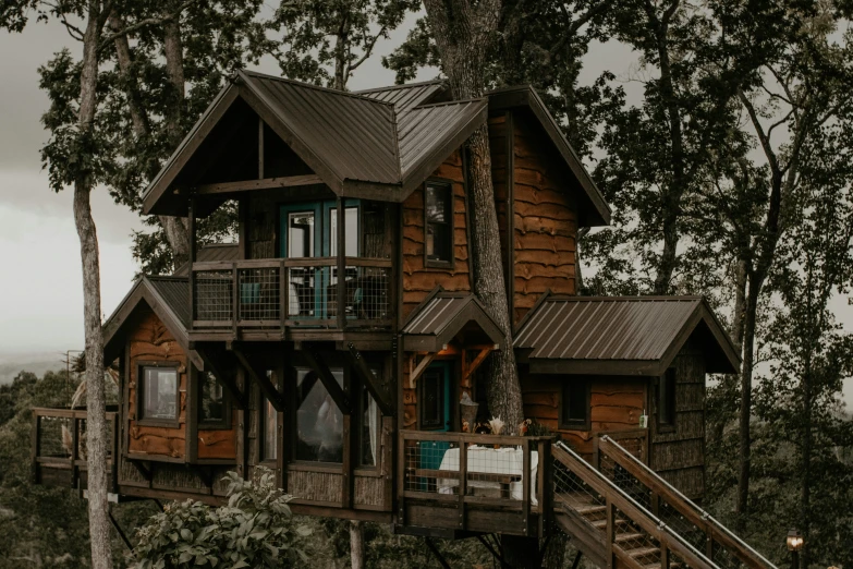 a tall wooden tree house with some windows and railings