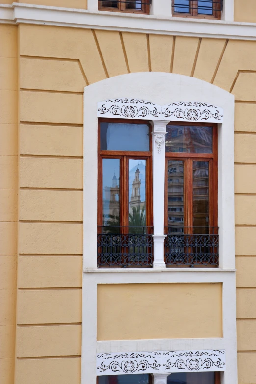 two windows sit in a tan building