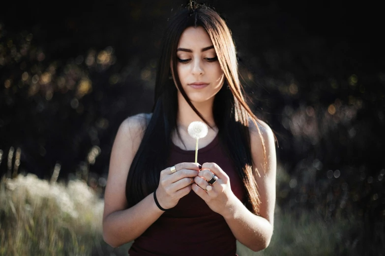 a woman holding a flower in her hands