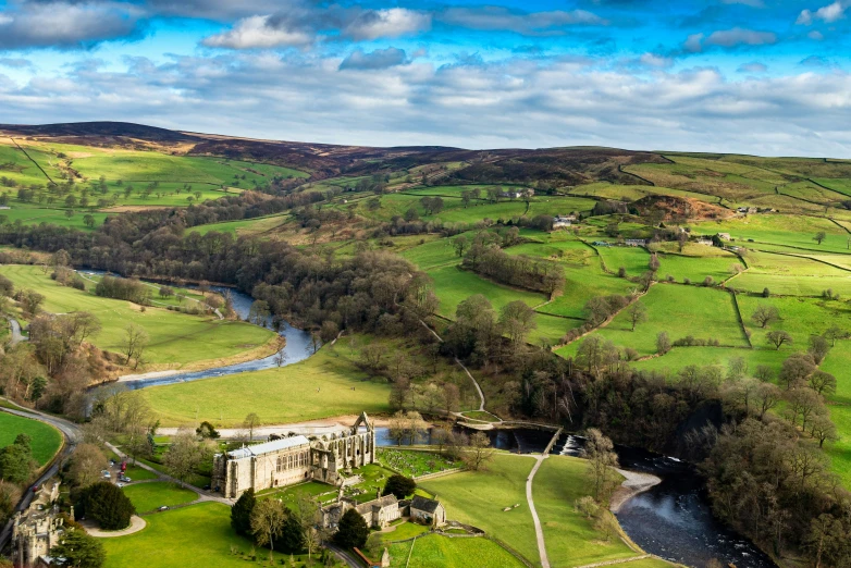 an aerial view of a rural scene with rivers and lush green hills