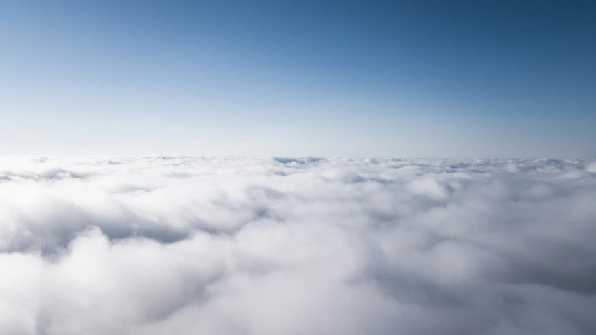 a view of the wing of an airplane over some clouds