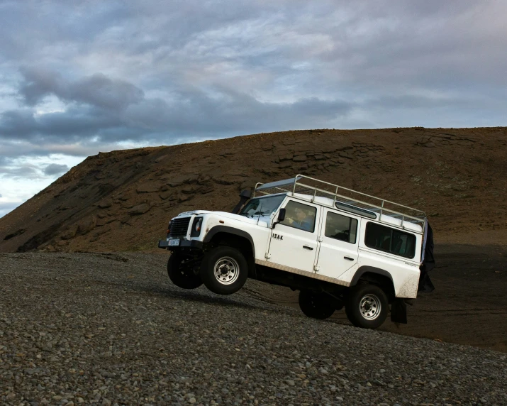 a white land cruiser is parked in the middle of the field