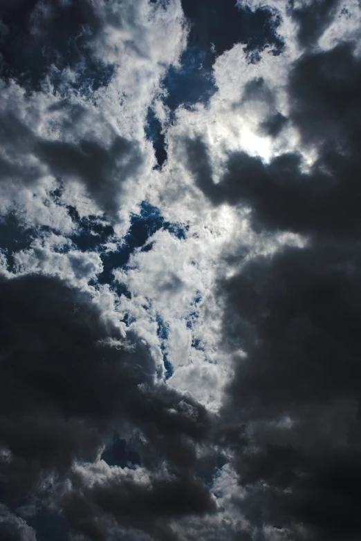 a cloudy sky with birds flying across it