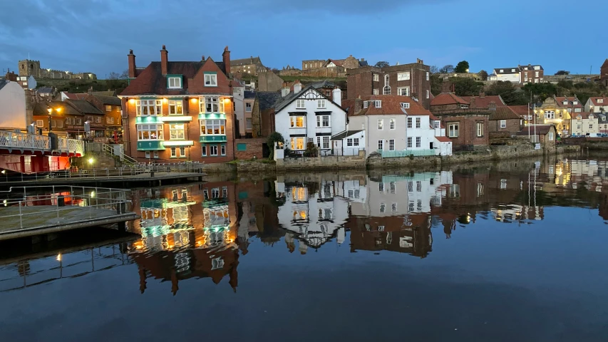 many buildings are shown along the water by the dock