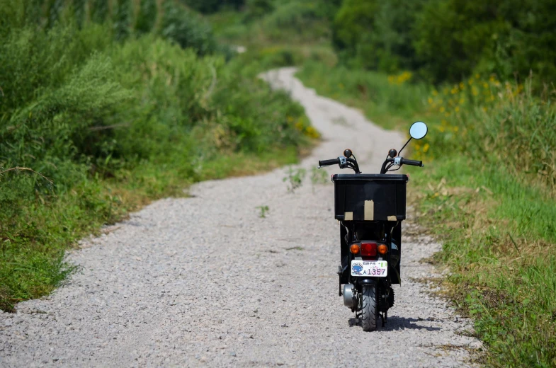 there is a bike parked along a dirt road