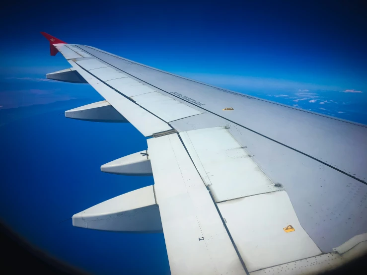 an airplane wing as it is flying over the ocean