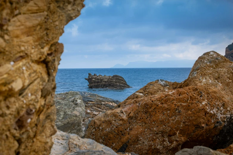 a rock is shown with some rocks and a body of water in the background