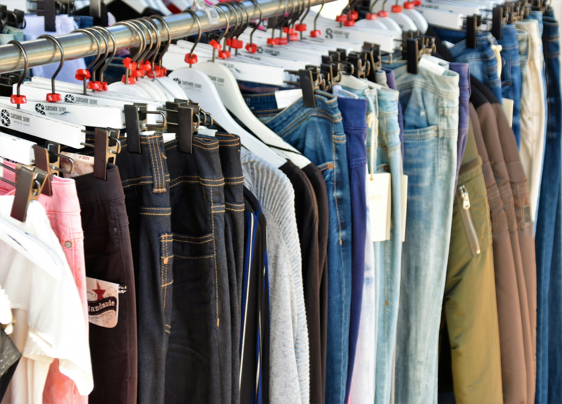 a rack with a variety of different colored jeans