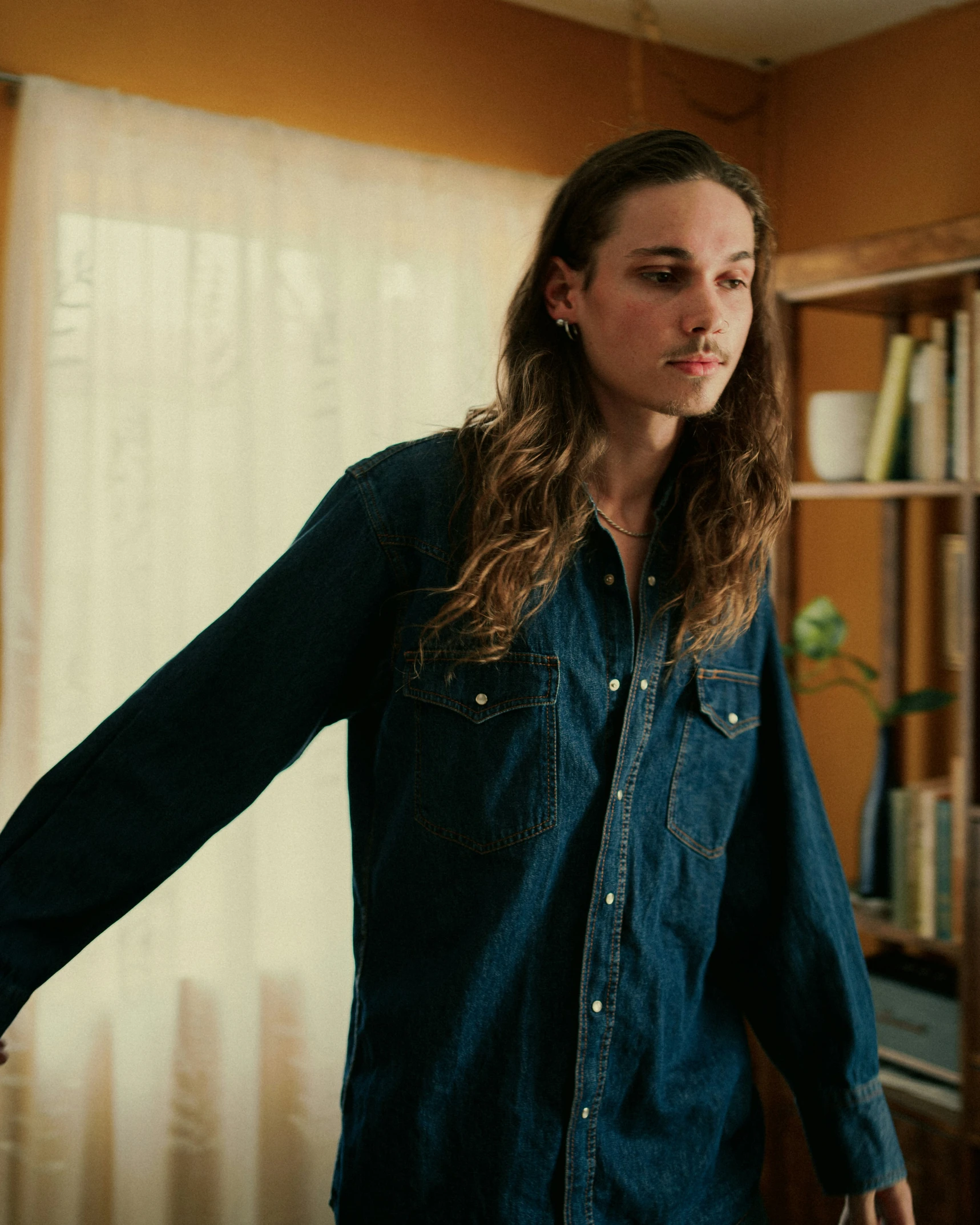 a young woman standing in front of a bookshelf