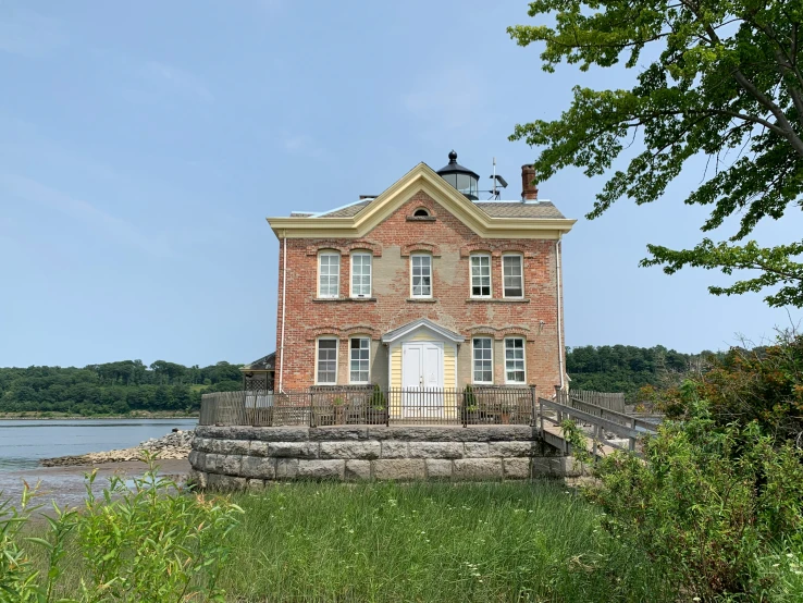 a house sitting on a small island with water behind it