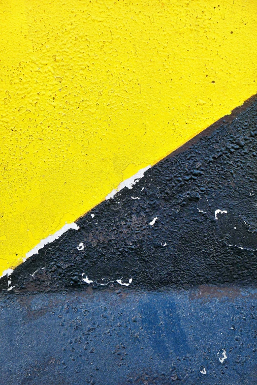 the corner of a road painted in yellow and blue