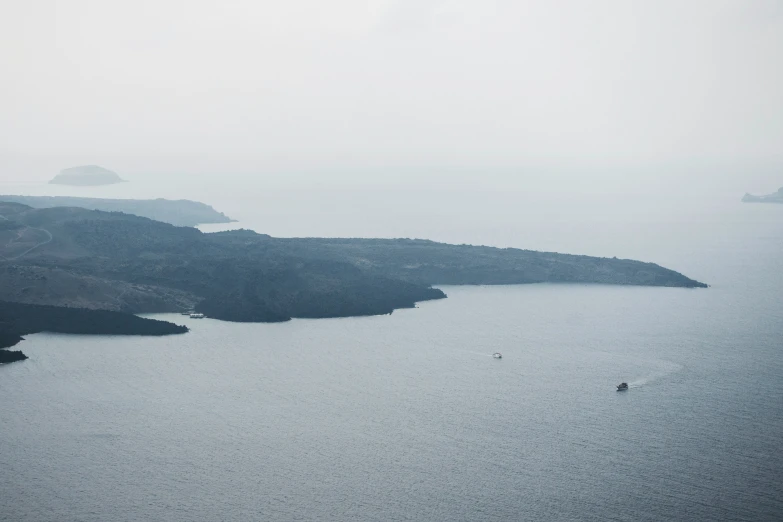 an ocean view from the air with two mountains in the distance