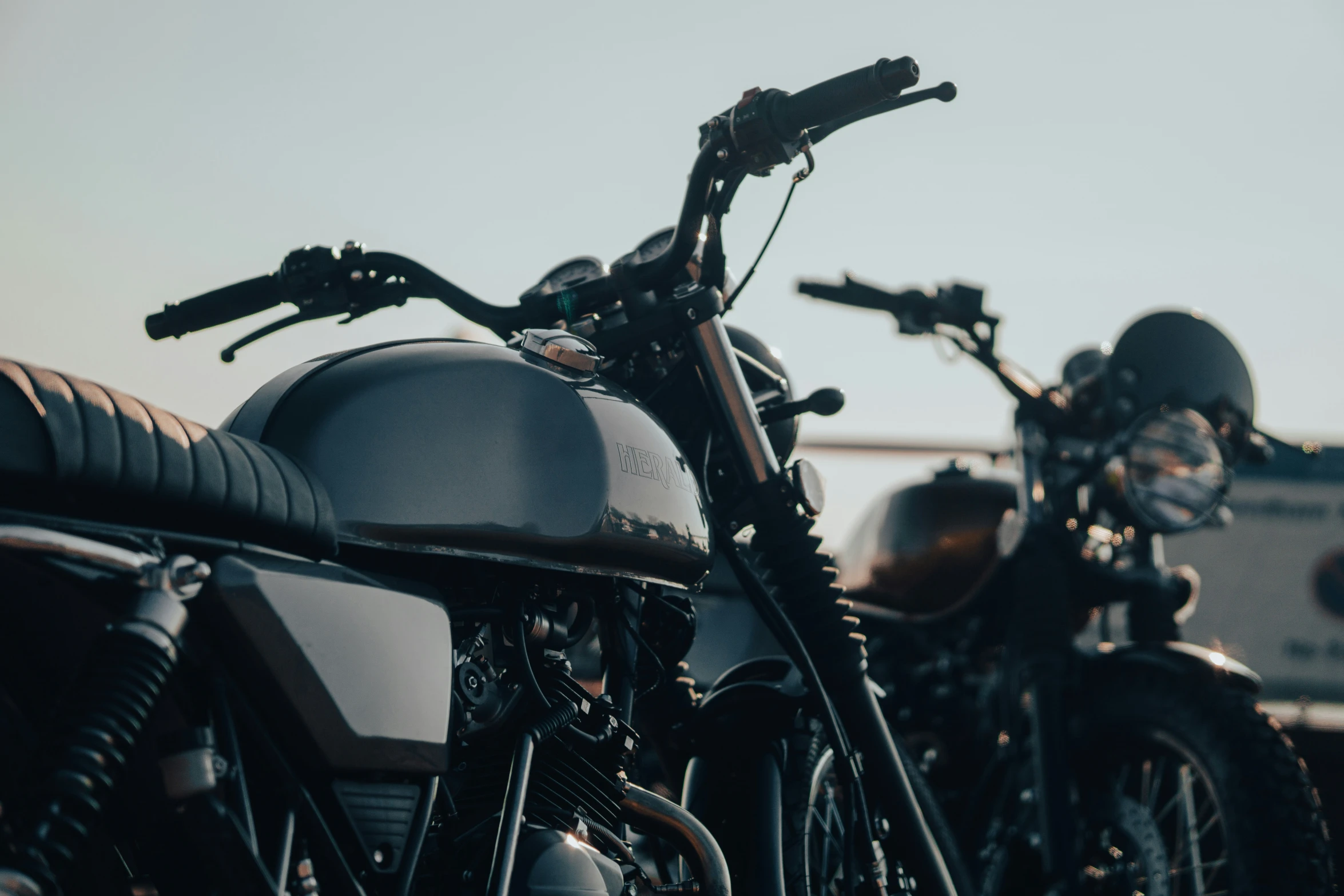 two parked motorcycles sitting next to each other