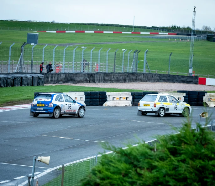 there are several different cars coming down this race track