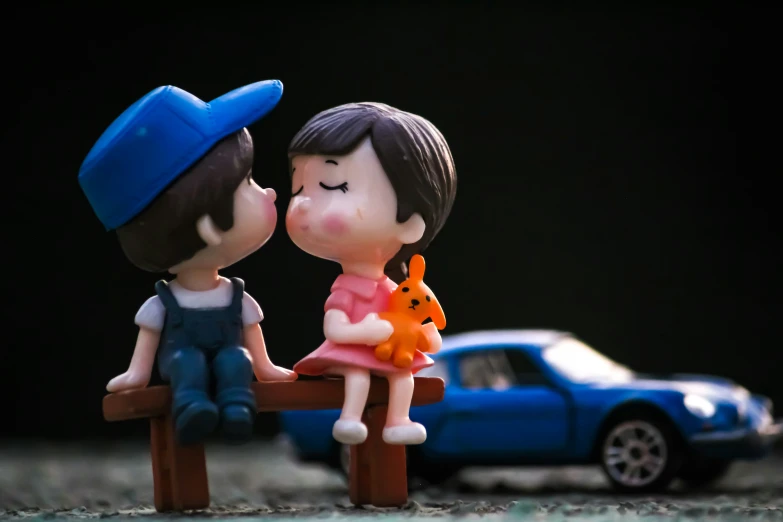 a couple sitting on a bench with a toy car