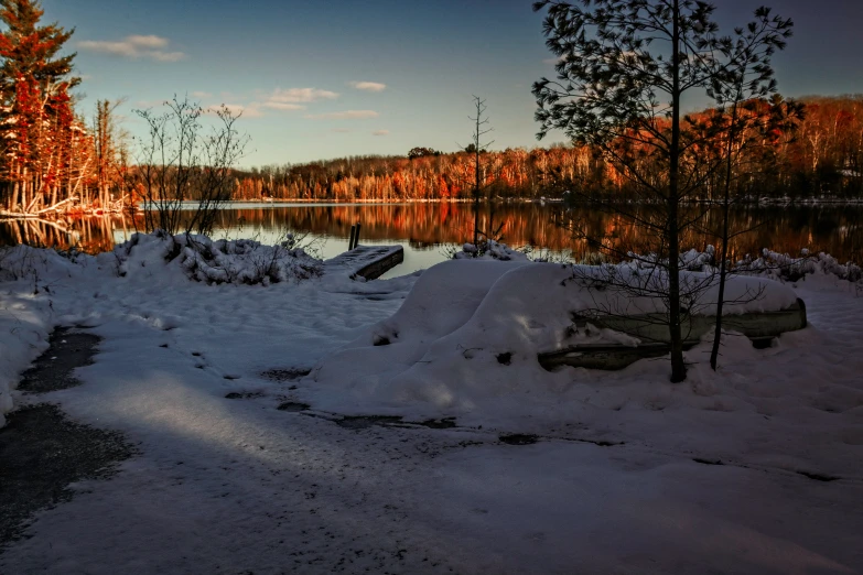 a large lake surrounded by snow covered trees