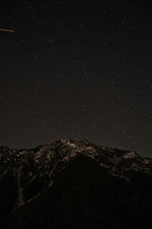 a plane flying over the top of a mountain