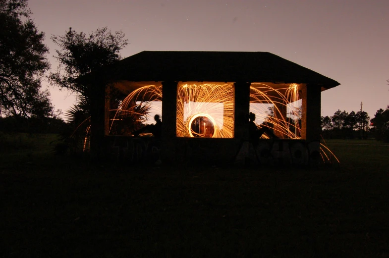 a picture of people sitting in the light of a gazebo