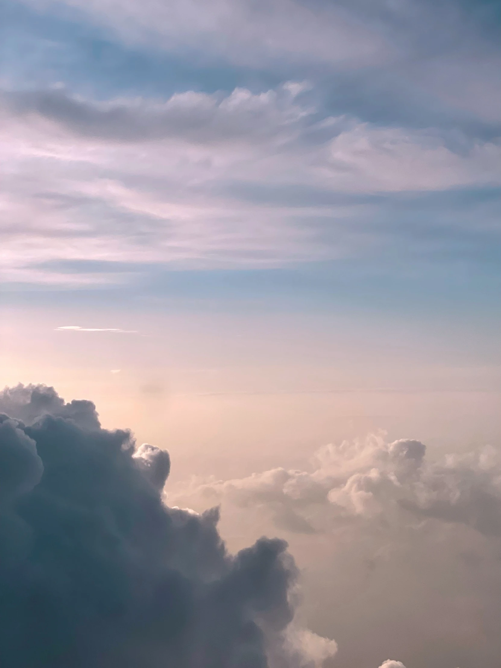 airplane flying through the clouds during sunset