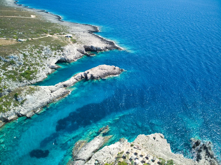 some rocks and blue water in a very blue ocean