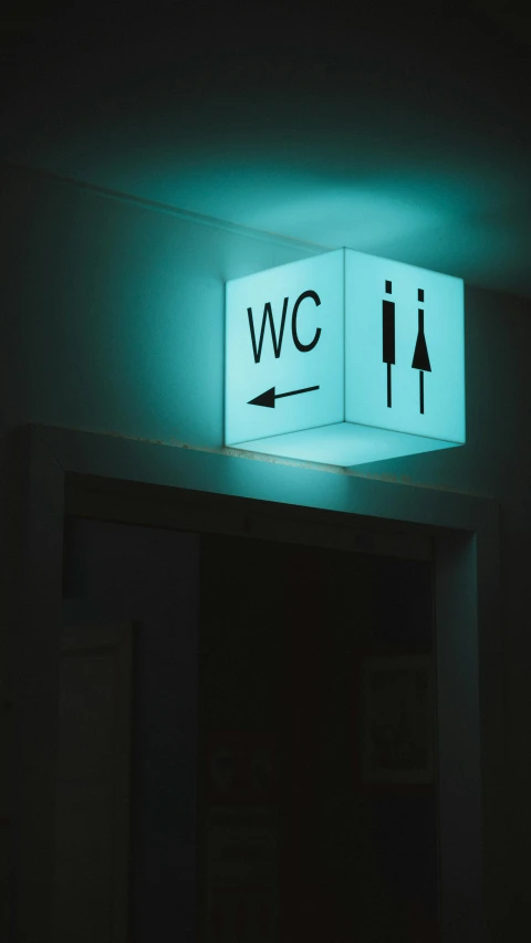 a bathroom with an illuminated box on the wall above