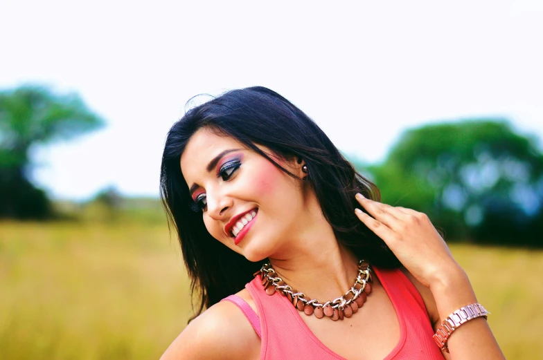 a woman wearing pink shirt holding her hair in the air