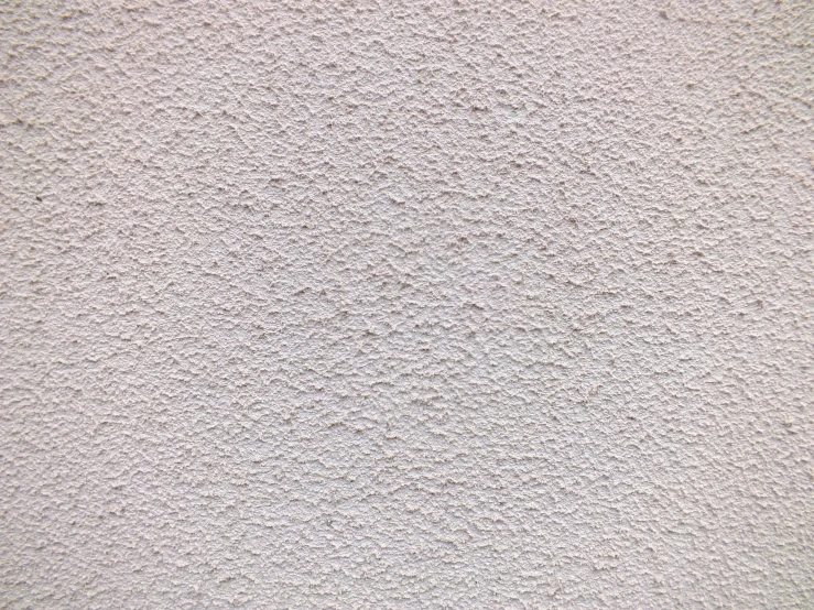 a wall of white stucco and light brown stains