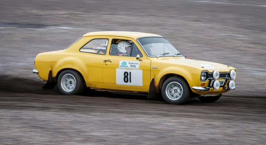 a small yellow race car is on a racetrack