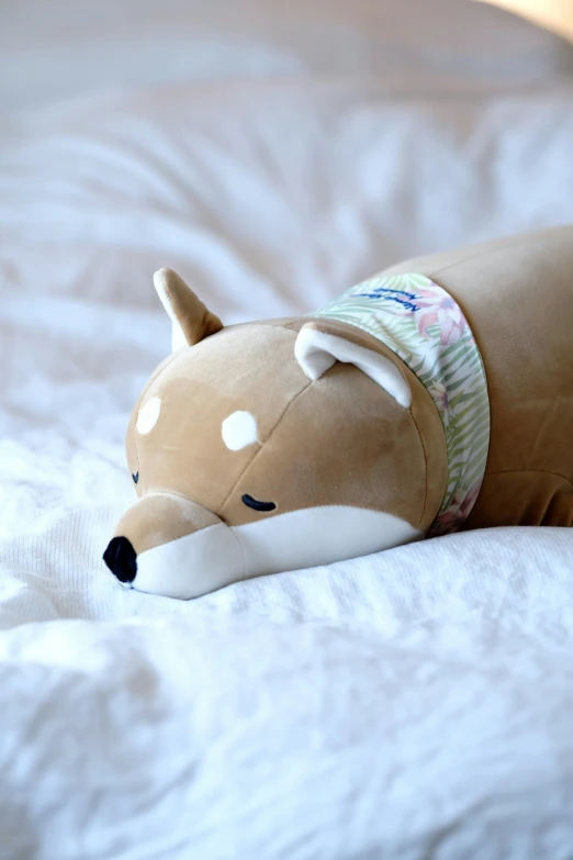 small stuffed animal laying on the bed, looking sad