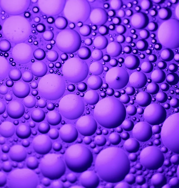 purple colored soap bubbles in a bowl of water