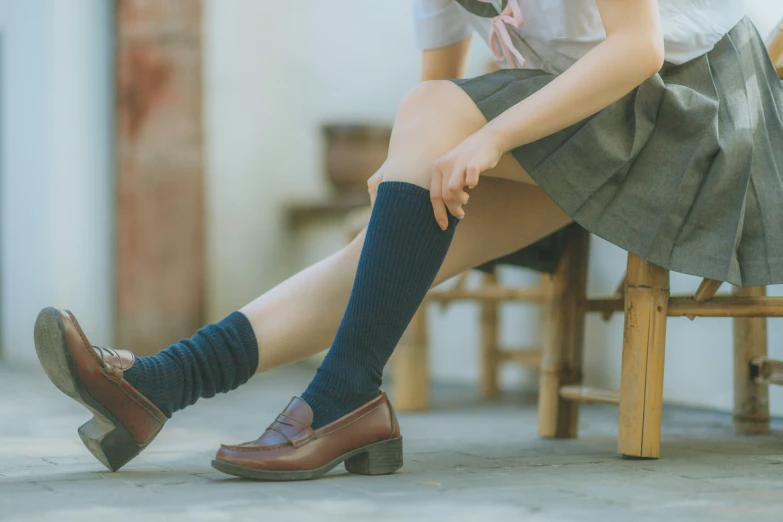 the woman in striped socks is sitting on a chair