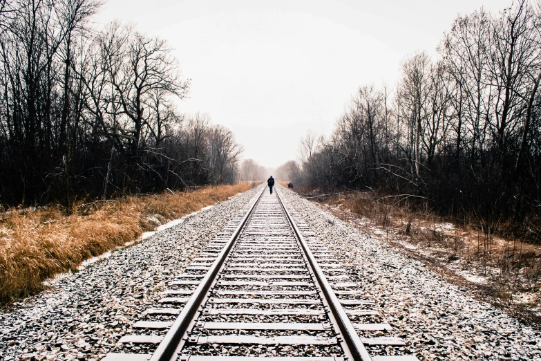 someone standing on the edge of train tracks