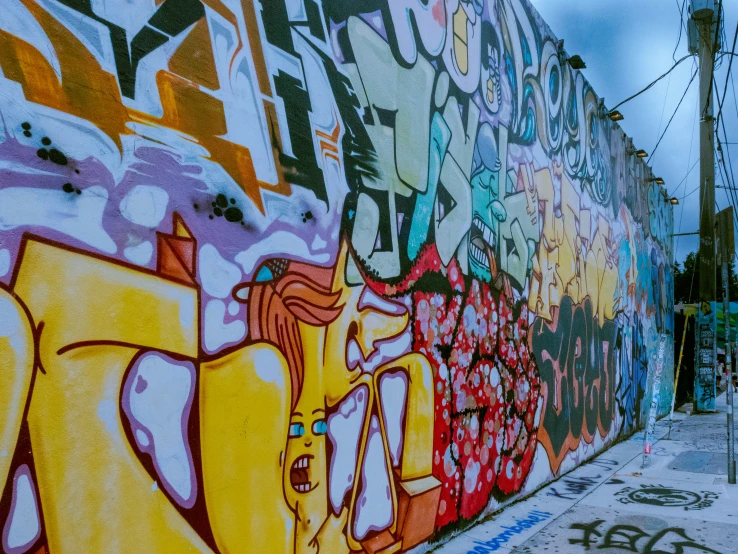 a wall covered in graffiti in an alley