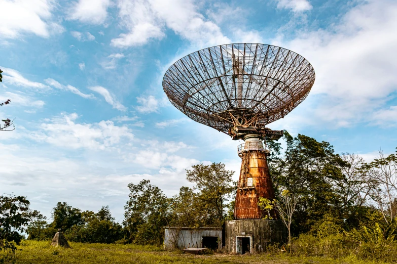 a very large satellite dish is in the middle of a grassy area