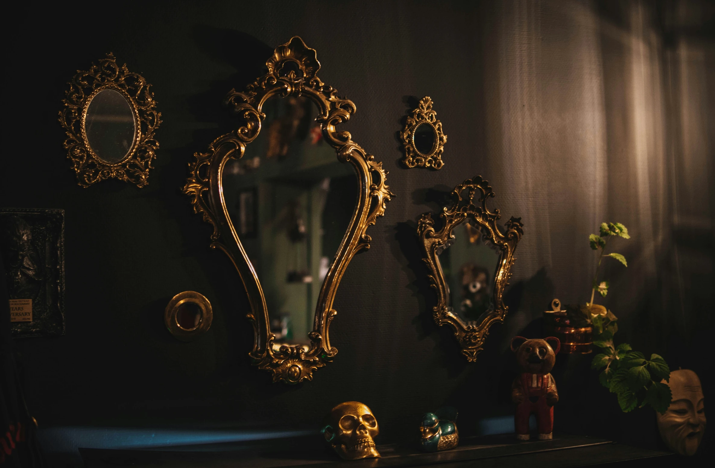 antique ss - plated mirrors, sculptures and figurines decorate a dark room