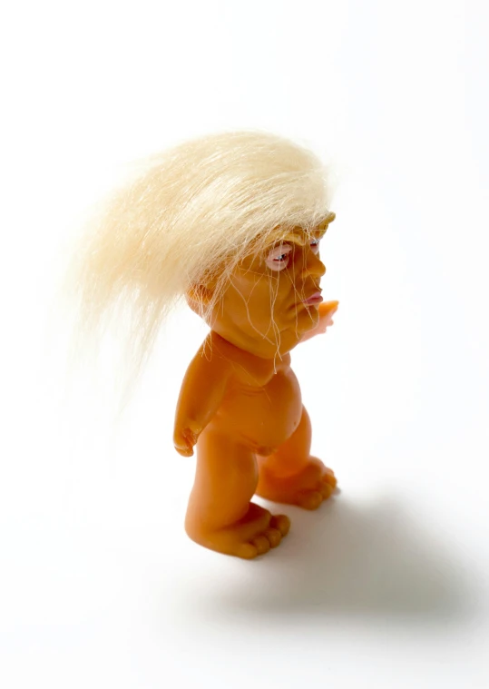 a little troll toy is standing on a white surface