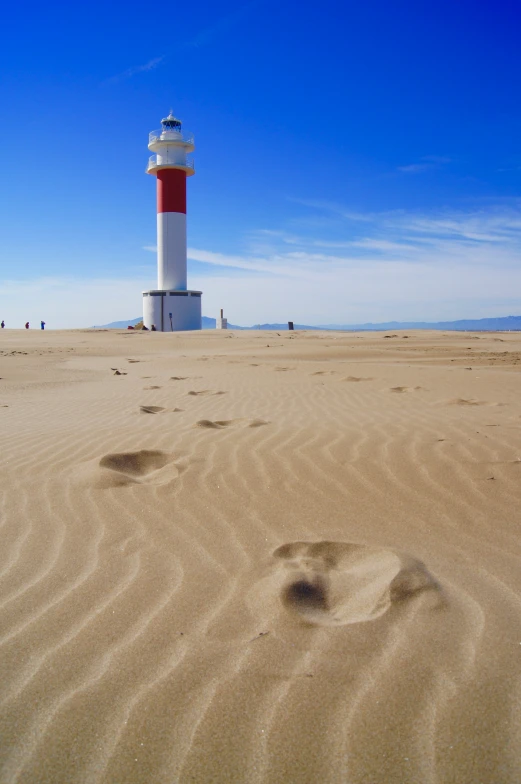 this is a lighthouse in the desert with people walking around