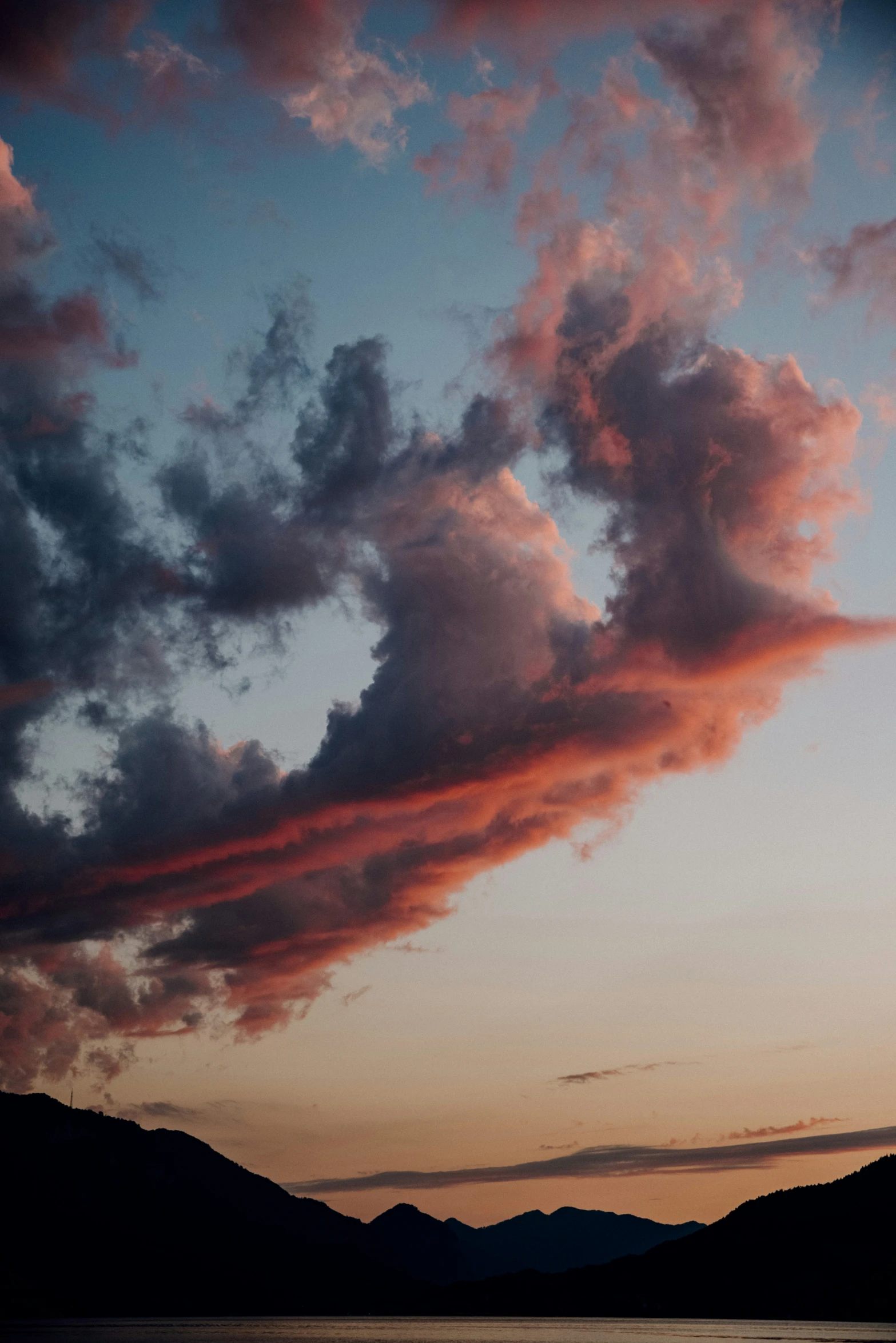 a plane flying in the sky while the sun sets