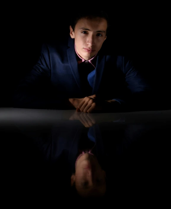 a man sitting down looking in the dark