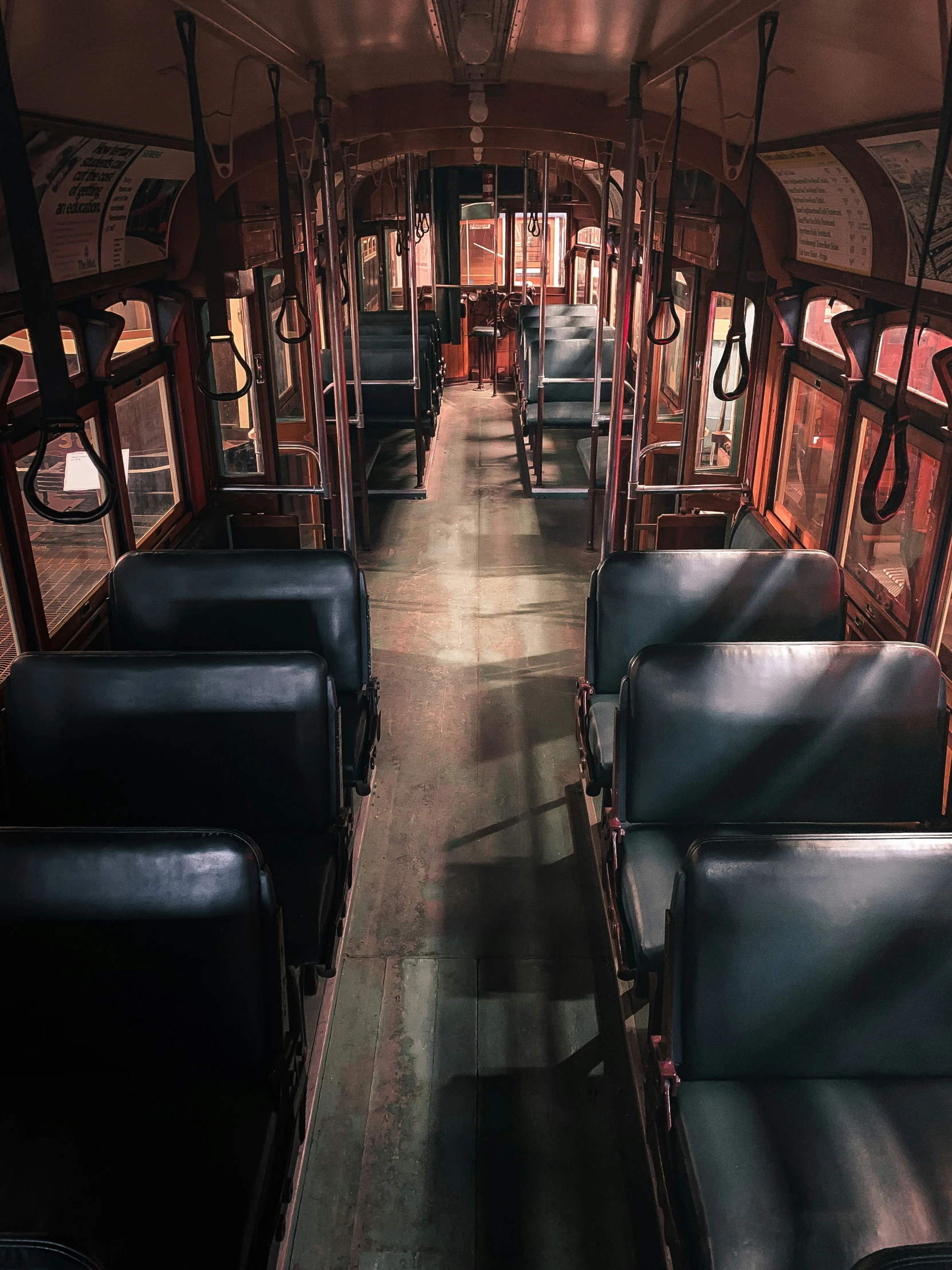 an empty train car, with black seats and wood flooring