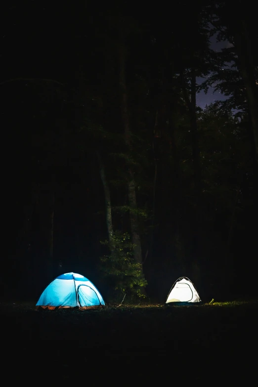 two tents in the dark with lights in them