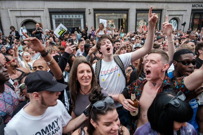 a group of people standing around each other with one woman raising her hands