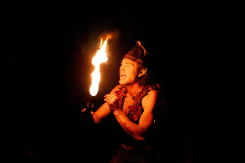 a woman holding up a candle in the dark