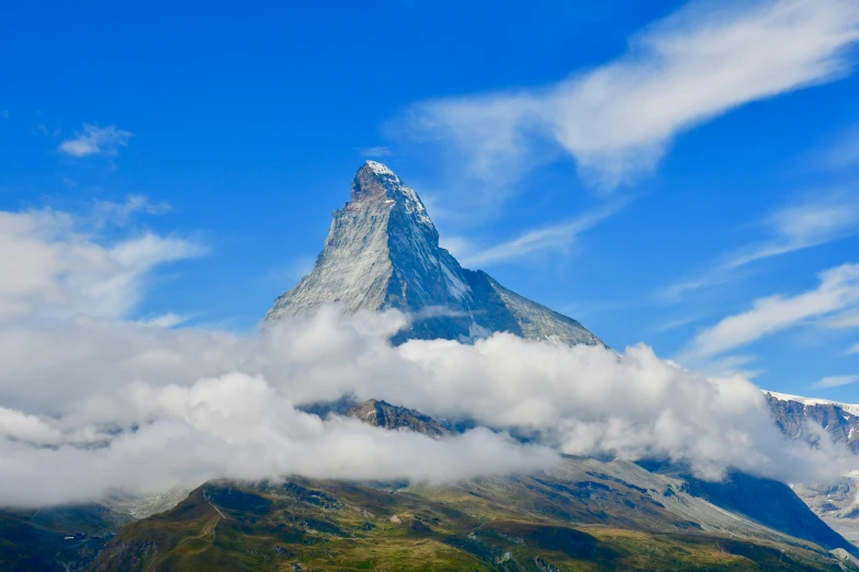 a mountain peak with clouds around it