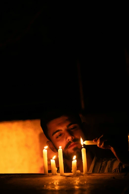 the man is lighting the candles in his kitchen