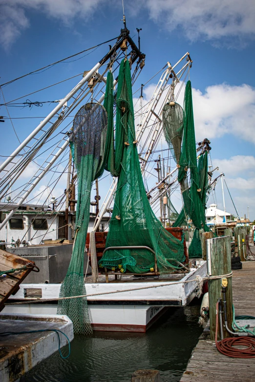 many green fishing nets sit by some docks